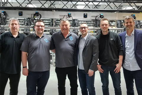 Simon Stuart and Wes Bailey (centre) mark the acquisition with their staff members